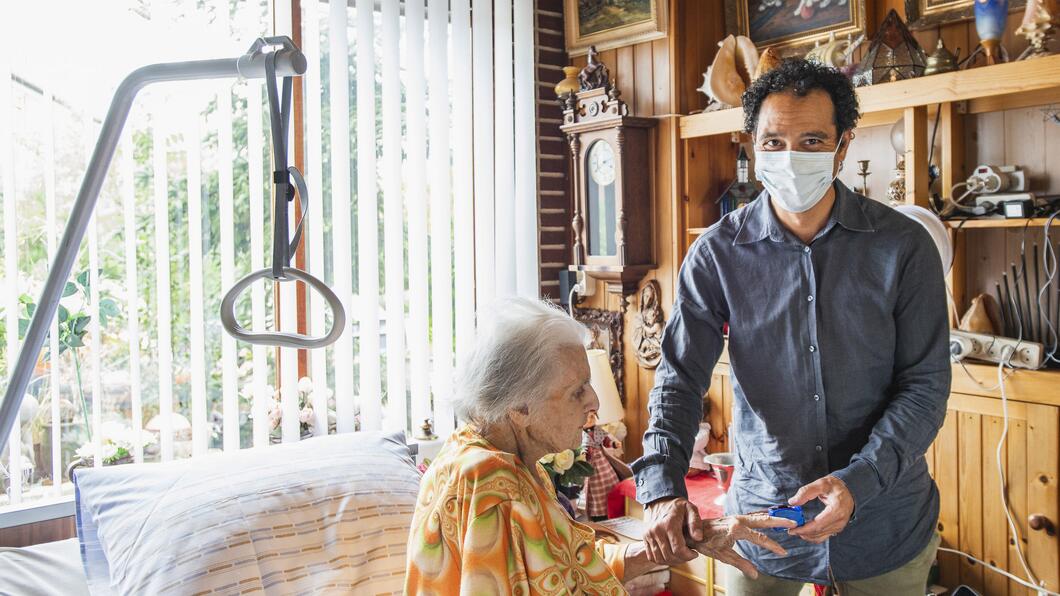 Arts verleent zorg aan patiënt in huis